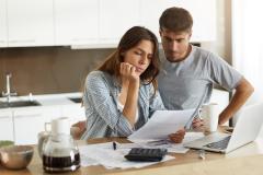 couple en train de regarder des papiers dans leur cuisine