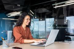 Femme brune heureuse sur son ordinateur
