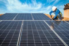 Une femme installe des panneaux solaires