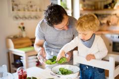 Un jeune papa en train de cuisiner avec son enfant