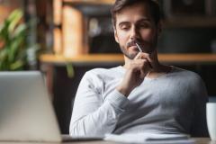 homme réfléchit devant son ordinateur