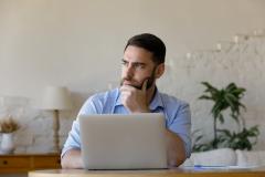 homme réfléchit devant son ordinateur