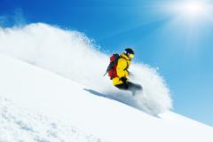 Snowboarder avec doudoune jaune dans les Alpes