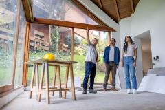 Couple avec entrepreneur regardent les travaux de rénovation réalisés dans leur maison 