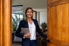 Agent immobilier femme qui ouvre la porte d'entrée.