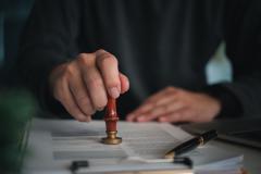 Un agent marque impose un sceau sur un document administratif.