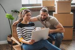 couple-entoure-de-cartons-regarde-les-demarches-pour-demenagement