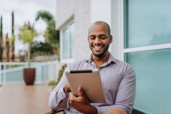Professionnel masculin sur sa tablette en extérieur.