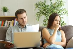 couple séparé sur canapé se renseigne sur les modalités de partage de la vente de la maison et des biens 