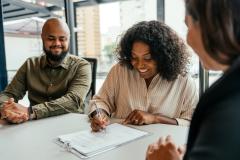 Un couple signe son contrat chez le notaire pour devenir propriétaire.