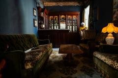 Salon très sombre, de style victorien, avec de gros meubles. 