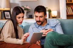 couple recherche sur sa tablette le montant minimum de l'apport pour acheter une maison 