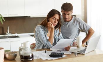 couple en train de regarder des papiers dans leur cuisine