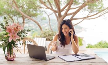 femme sur sa terrasse téléphone et regarde son ordinateur