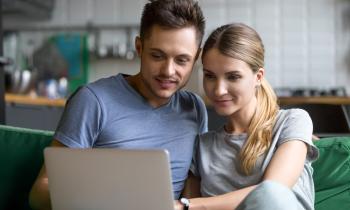 couple regarde son ordinateur avec le sourire 