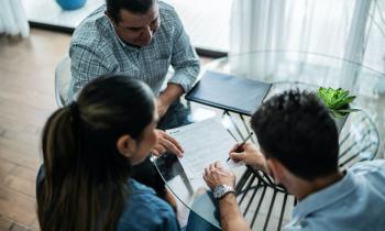 Un couple signant une promesse de location avec le propriétaire