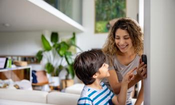 Une mère montre à son fils comment programmer le thermostat