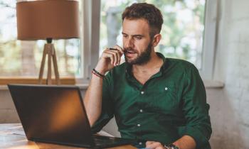 Homme découvre sur son ordinateur les conséquences de la fin de l'amortissement pour les location Airbnb