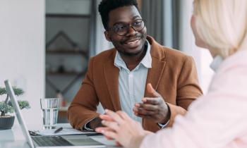 Un banquier parle à sa cliente qui souhaite contracter un crédit immobilier. 