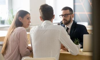 un homme et une femme devant le notaire signent un compromis de vente