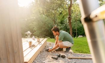 homme en train de visser sa terrasse en bois