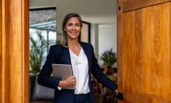 Agent immobilier femme qui ouvre la porte d'entrée.