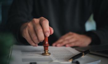 Un agent marque impose un sceau sur un document administratif.