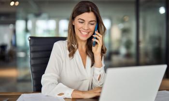 Un agent immobilier femme sur son ordinateur parle au téléphone.