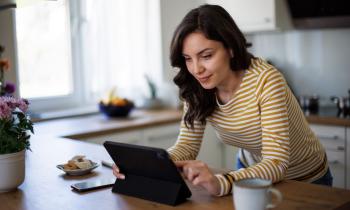 femme-lit-les-actualites-sur-sa-tablette-dans-sa-cuisine