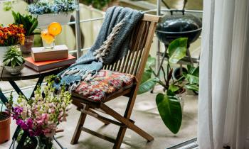 petit balcon avec plantes, table, chaise et barbecue