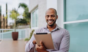 Professionnel masculin sur sa tablette en extérieur.