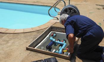 Un homme effectue des réglages sur le système de filtration de sa piscine