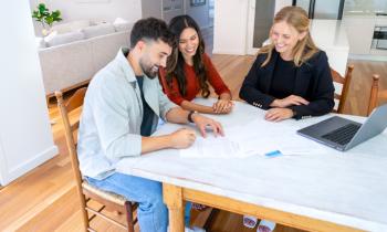 Un couple d'acquéreurs et une femme agent immobilier.