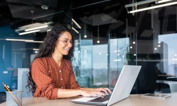 Femme tapant sur son clavier d'ordinateur, au bureau. 