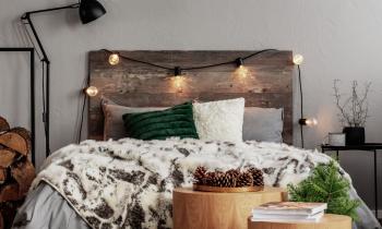 Chambre à la déco chaleureuse avec tête de lit en bois et guirlande lumineuse