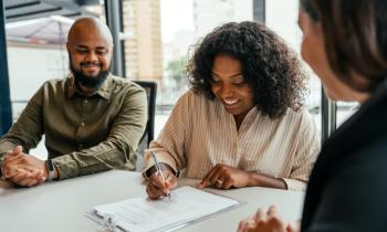 Un couple signe son contrat chez le notaire pour devenir propriétaire.