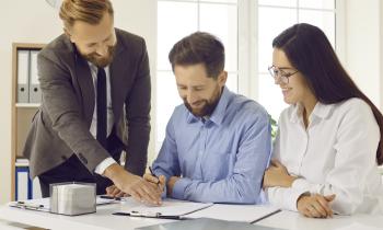 Un couple signe des documents officiels en présence de son notaire