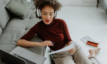 Jeune femme relit sa lettre de résiliation de bail près de son ordinateur