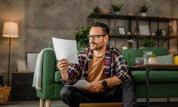 homme assis dans son salon vérifie ses diagnostics immobiliers