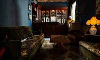 Salon très sombre, de style victorien, avec de gros meubles. 