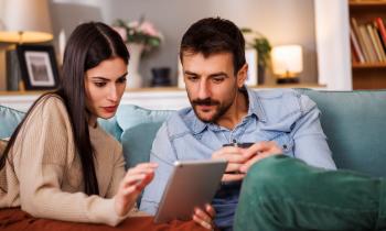 couple recherche sur sa tablette le montant minimum de l'apport pour acheter une maison 