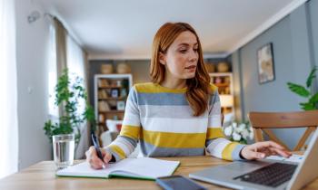 Jeune-femme-regarde-sur-son-ordianteur-la-liste-des-meubles-obligatoires-d-une-location-meublée