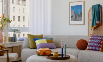 Salon moderne avec un canapé gris et des éléments de déco très colorés. 