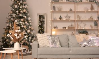 Christmas modern living room with Christmas tree, sofa, shelf with Christmas decorations. Happy new year and merry christmas