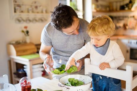 Un jeune papa en train de cuisiner avec son enfant