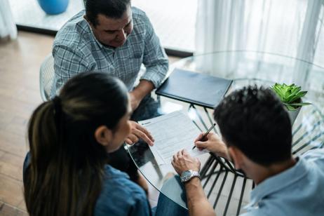 Un couple signant une promesse de location avec le propriétaire