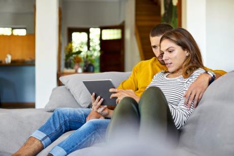 Couple regarde sur sa tablette s'ils pourront louer leur appartement en 2025