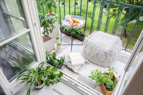 joli balcon avec coussins d'extérieur, plantes et guirlandes