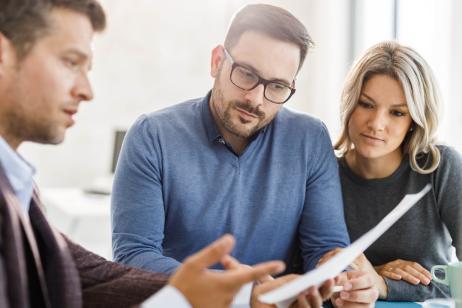 Un couple étudie des documents avec son banquier lors d'un rendez-vous