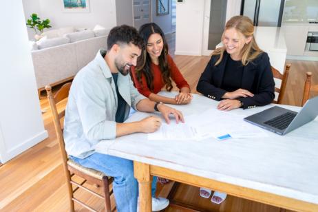 Un couple d'acquéreurs et une femme agent immobilier. 